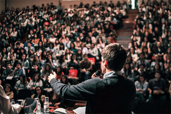A photo of a speaker in front of a blurred crowd